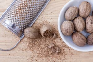 Full nutmeg in a bowl and grated